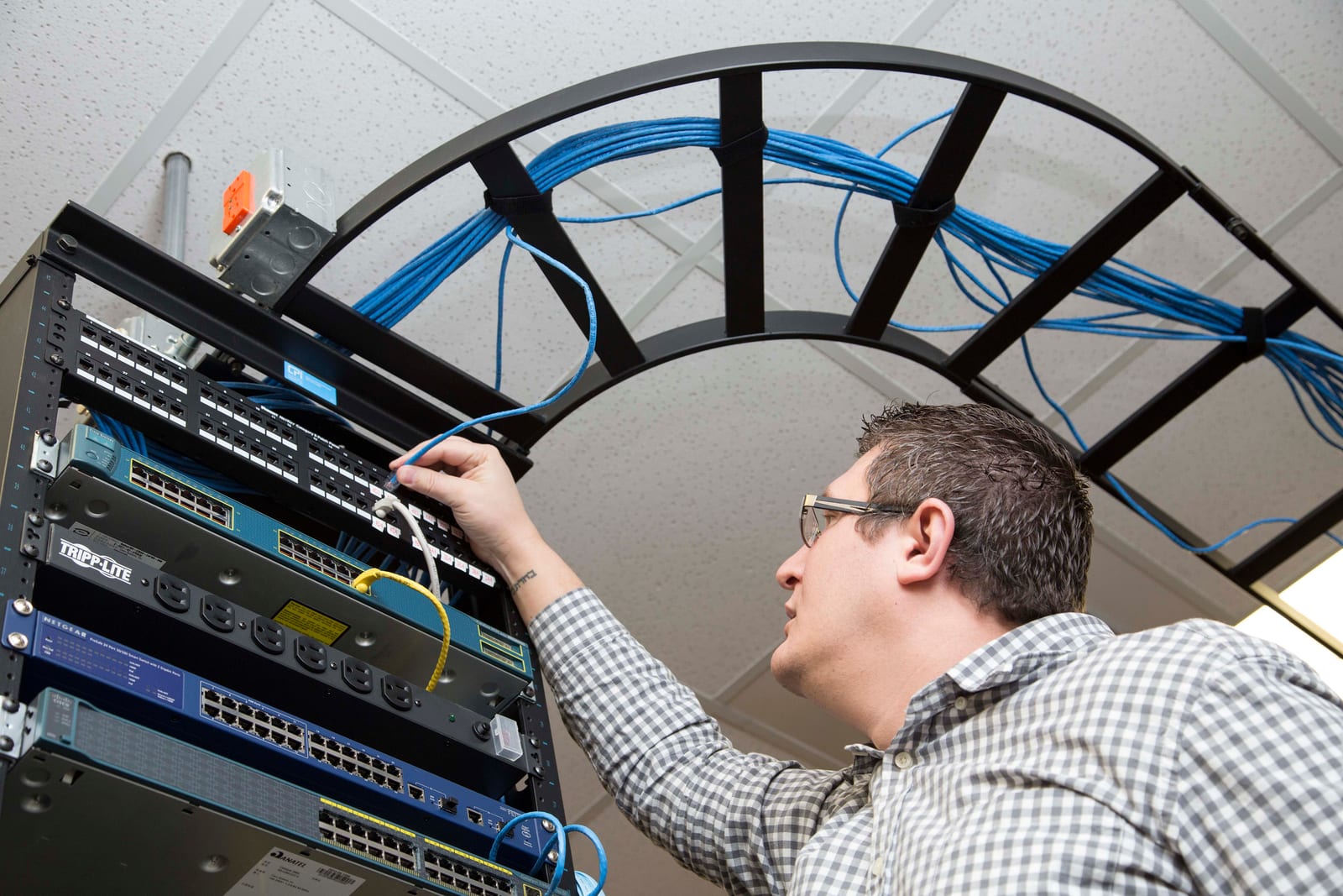 Technician working on network cables in a data center